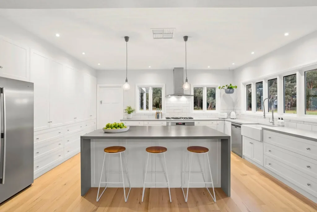 Modern kitchen, white cabinets, stainless appliances, large island.