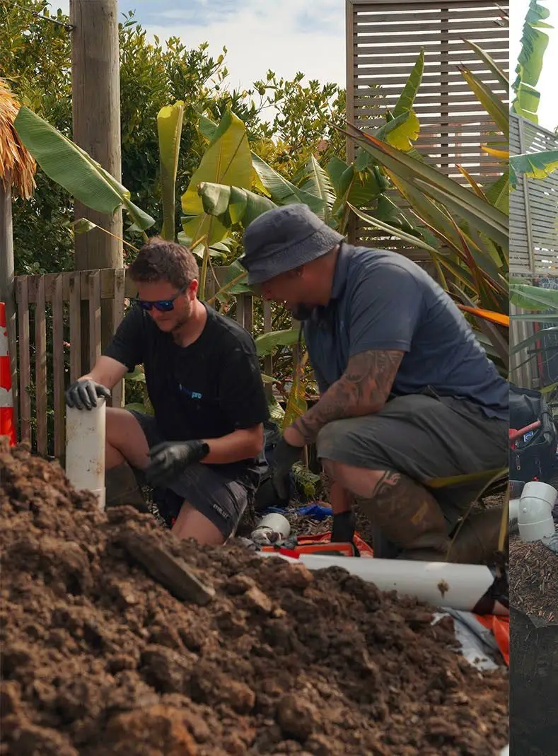 Men fixing pipes at muddy site.