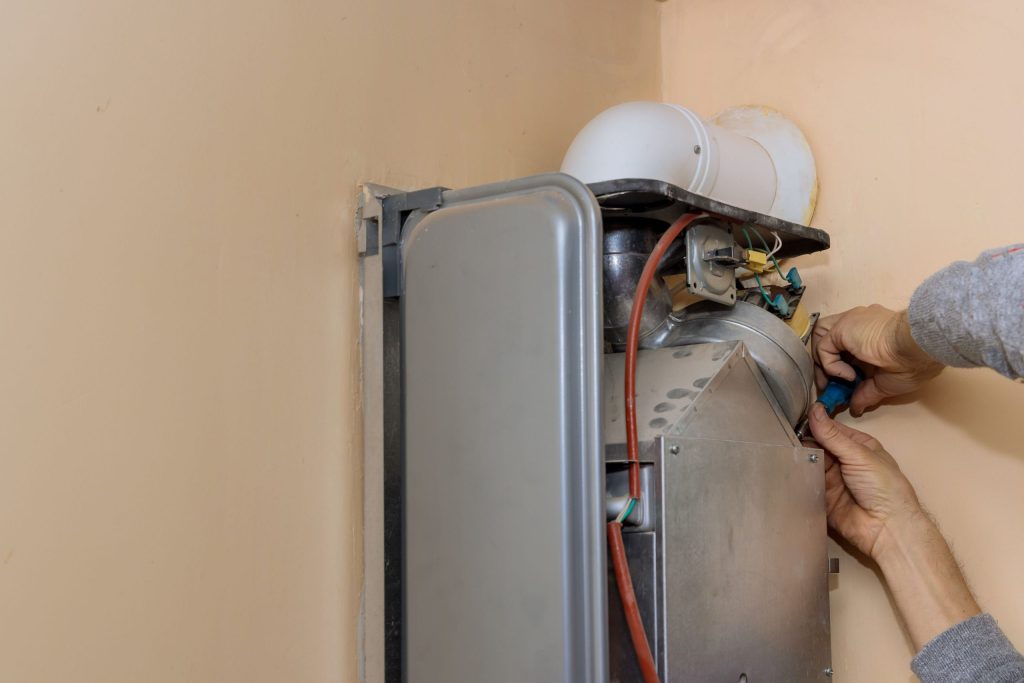 Repairing gas boiler on wall.