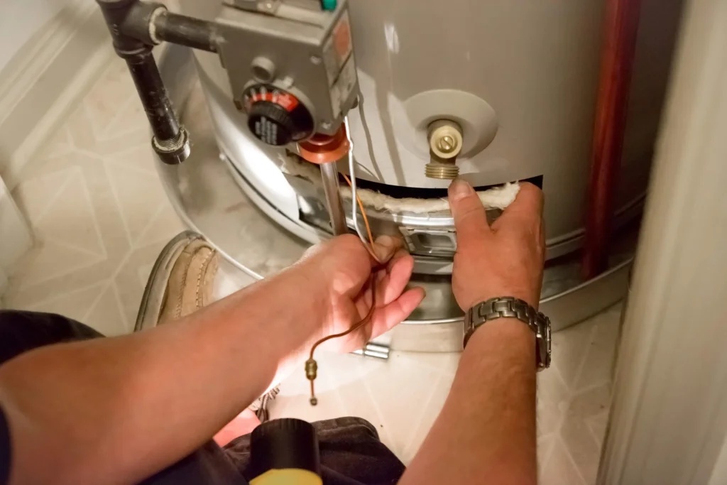 Fixing water heater with screwdriver.