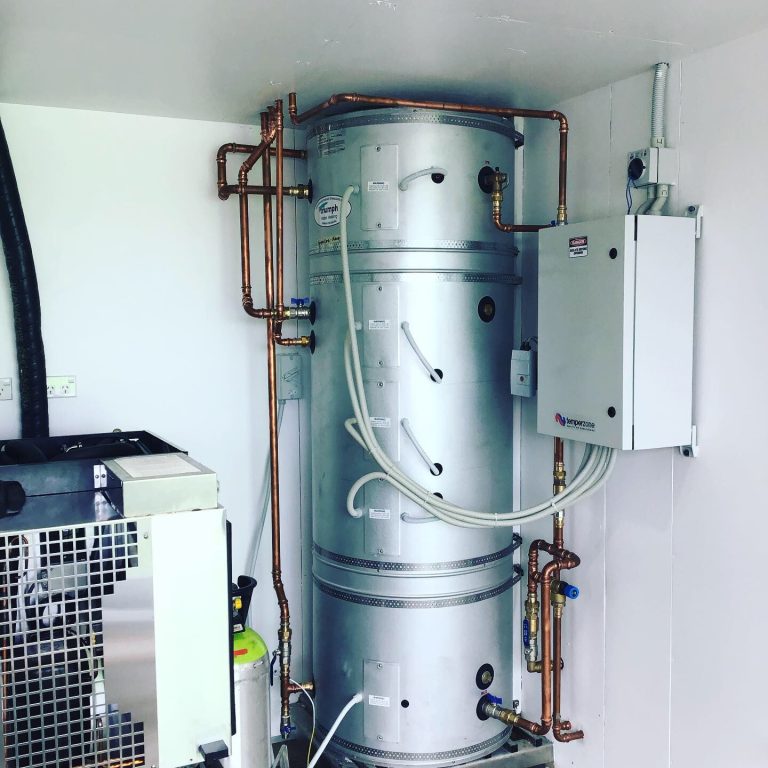 Metal hot water tank with pipes.
