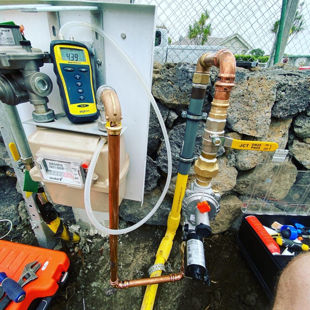 Outdoor gas meter, pipes, pressure gauge.