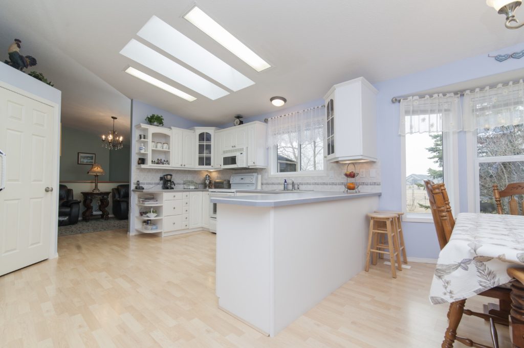 Kitchen with island, skylights, dining table.